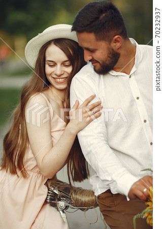 Couple with vintage bicycle in the summer park Couple with vintage bicycle in the summer park 70232937