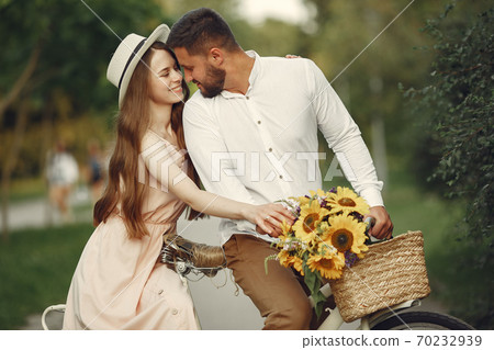 Couple with vintage bicycle in the summer park Couple with vintage bicycle in the summer park 70232939