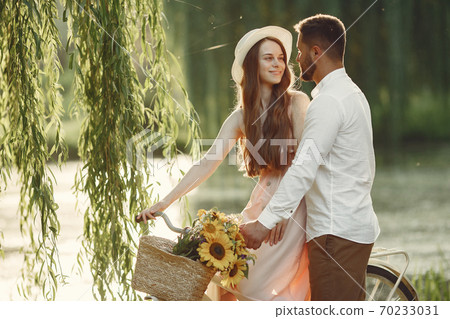 Couple with vintage bicycle in the summer park Couple with vintage bicycle in the summer park 70233031