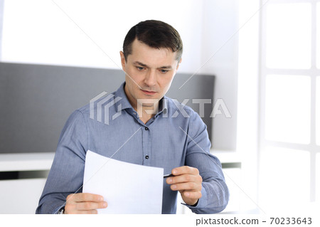 Businessman working with tablet computer in modern office. Headshot of male entrepreneur or company director at workplace. Business concept 70233643