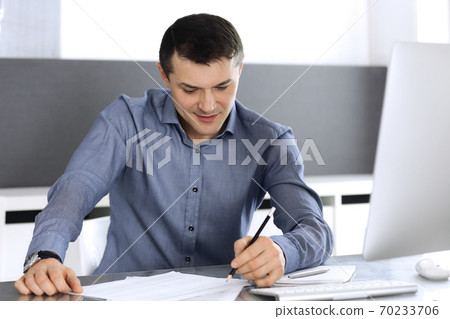 Businessman working with computer in modern office. Headshot of male entrepreneur or company director at workplace. Business concept Businessman working with computer in modern office. Headshot of male entrepreneur or company director at workplace. Business concept 70233706