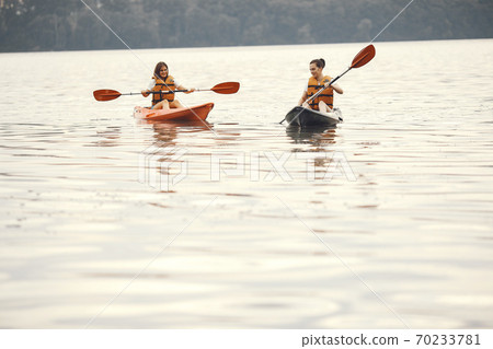 Women paddling on a lake in a kayak 70233781