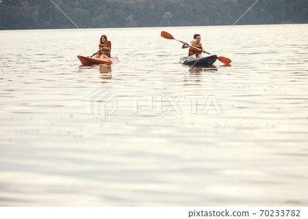 Women paddling on a lake in a kayak 70233782