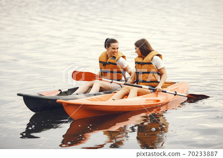 Women paddling on a lake in a kayak Women paddling on a lake in a kayak 70233887