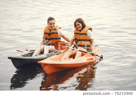 Women paddling on a lake in a kayak Women paddling on a lake in a kayak 70233900