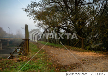 abandoned metal bridge in morning fog. dangerous construction in autumnal countryside scenery at sunrise abandoned metal bridge in morning fog. dangerous construction in autumnal countryside scenery at sunrise 70234447