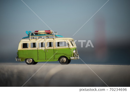 Lisbon - Portugal - 29 September 2020 - Closeup of miniature van Volkswagen toy on stoned wall on suspension bridge background 70234696