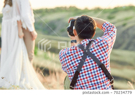 wedding photographer takes pictures of bride and groom 70234779