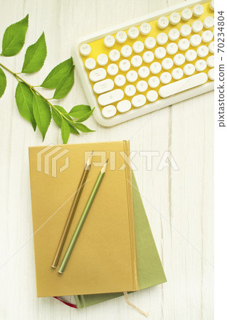 Yellow keyboard and writing instruments and books 70234804