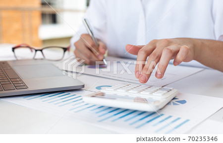 Accounting businessmen are calculating income-expenditure and analyzing real estate investment data, Financial and tax systems concept. Accounting businessmen are calculating income-expenditure and analyzing real estate investment data, Financial and tax systems concept. 70235346