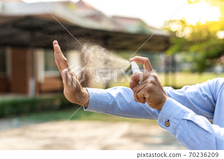 Young man uses a spray of alcohol to get rid of bacteria and viruses, Inhibition and prevention of corona or Covid-19 virus infection using 70 percent alcohol, protect virus concept. 70236209