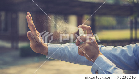Young man uses a spray of alcohol to get rid of bacteria and viruses, Inhibition and prevention of corona or Covid-19 virus infection using 70 percent alcohol, protect virus concept. 70236210