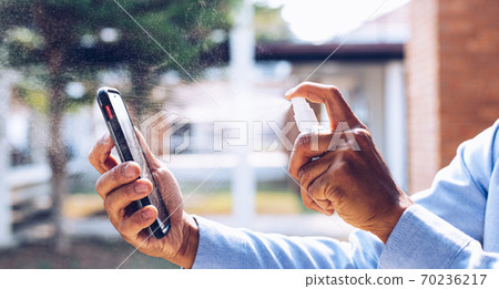Young man uses a spray of alcohol to get rid of bacteria and viruses, Inhibition and prevention of corona or Covid-19 virus infection using 70 percent alcohol, protect virus concept. Young man uses a spray of alcohol to get rid of bacteria and viruses, Inhibition and prevention of corona or Covid-19 virus infection using 70 percent alcohol, protect virus concept. 70236217