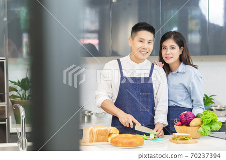 asian man and woman in kitchen. asian man and woman in kitchen. 70237394