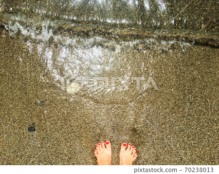 standing on wet sand on sea beach standing on wet sand on sea beach 70238013