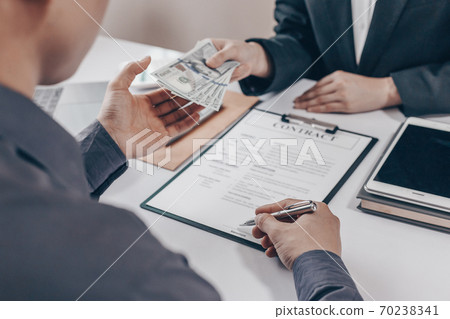 Businessmen give dollars to bribe employees in signing contracts to buy illegal land and real estate, Business fraud and social injustice, corruption and bribery concept. 70238341