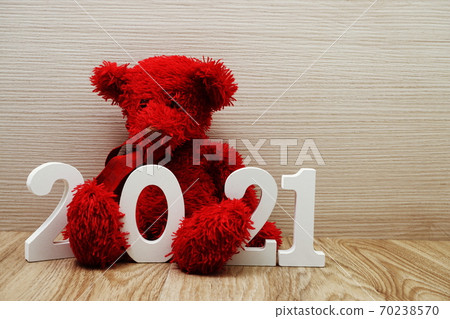 2021 Happy New Year and teddy bear with space copy on wooden background 70238570
