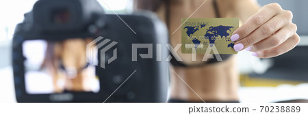 Woman in lingerie stockings holds out bank plastic card to camera Woman in lingerie stockings holds out bank plastic card to camera 70238889