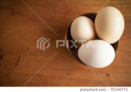 Three eggs in a wooden cup Three eggs in a wooden cup 70240755