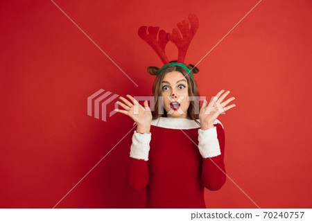 Beautiful woman like Christmas deer isolated on red background. Concept of 2021 New Year's, winter mood, holidays. 70240757