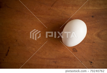 A white fresh egg on a wooden board A white fresh egg on a wooden board 70240762