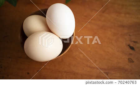Three eggs in a wooden cup 2 Three eggs in a wooden cup 2 70240763