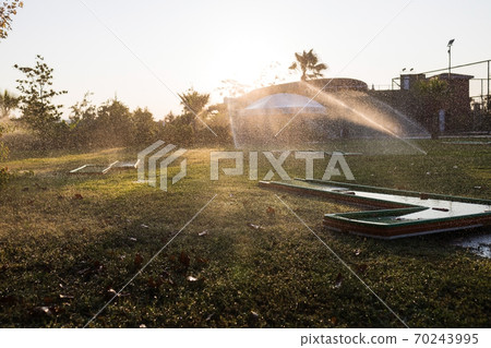 Turkey Alanya, 20 October 2019: A beautiful green lawn park with trees and a golf course is sprayed Turkey Alanya, 20 October 2019: A beautiful green lawn park with trees and a golf course is sprayed 70243995