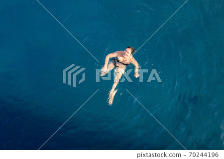 aerial top view happy young woman in black swimsuit swims in the Red Sea, Egypt, Sharm el Sheikh aerial top view happy young woman in black swimsuit swims in the Red Sea, Egypt, Sharm el Sheikh 70244196