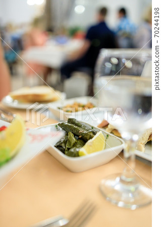 Traditional Turkish dish Yaprak sarm - rice in grape leaves. Serving in a Turkish restaurant Traditional Turkish dish Yaprak sarm - rice in grape leaves. Serving in a Turkish restaurant 70244198