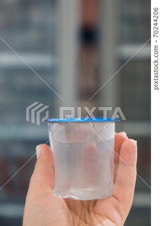 Disposable Turkish eco glass of clean water in a plastic bag. Convenient environmental capacity for 70244206
