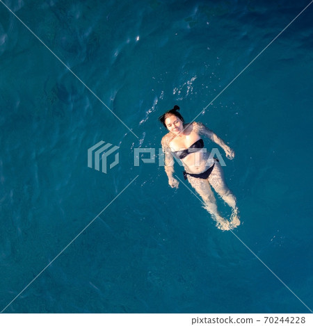 aerial top view happy young woman in black swimsuit swims in the Red Sea, Egypt, Sharm el Sheikh aerial top view happy young woman in black swimsuit swims in the Red Sea, Egypt, Sharm el Sheikh 70244228