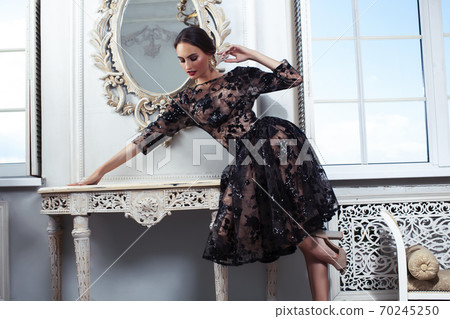 young pretty lady in black lace fashion style dress posing in rich interior of royal hotel room with mirror, luxury lifestyle people concept young pretty lady in black lace fashion style dress posing in rich interior of royal hotel room with mirror, luxury lifestyle people concept 70245250