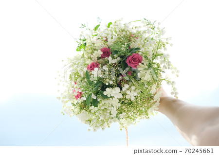 Close-up bouquet of fresh flowers rose and lily of the valley in woman hand 70245661