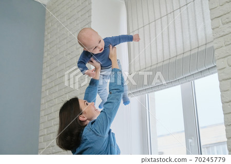 Happy young beautiful mother playing with toddler son Happy young beautiful mother playing with toddler son 70245779