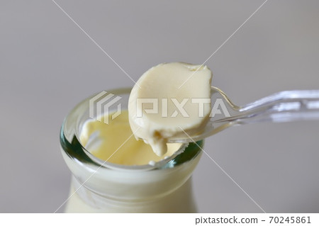 Smooth steamed pudding in a jar and a plastic spoon 70245861