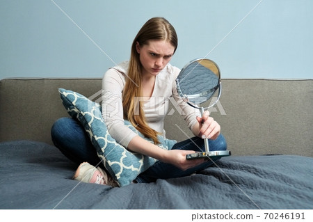 Beautiful young woman with make-up mirror sitting at home in bed Beautiful young woman with make-up mirror sitting at home in bed 70246191
