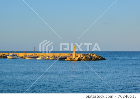 Small lighthouse, yachts on the pier, sunset at sea 70246513