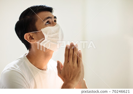 Asian man in face mask praying for coronavirus victim Asian man in face mask praying for coronavirus victim 70246621