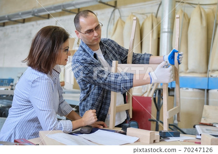 Joiner workshop, woman furniture designer and carpenter designing wooden chair 70247126