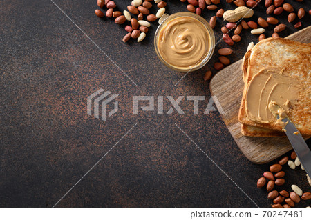 Peanut paste and crispy toasts on brown Peanut paste and crispy toasts on brown 70247481