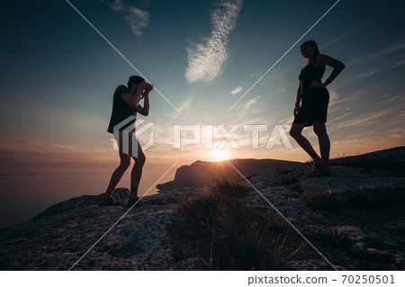 Cheese. Concentrated man taking photo of his girlfriend during picnic. 70250501