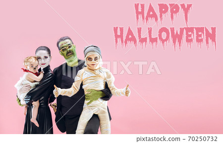 Young family as zombies on pink background, halloween time, flyer with copyspace 70250732