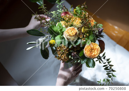 Female hand with a bouquet of roses 70250808