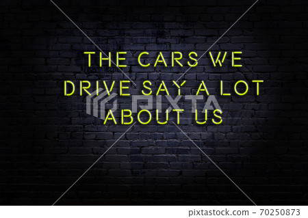 Wise quote. Neon inscription against brick wall 70250873