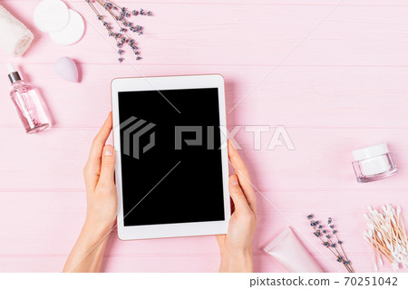 Flat lay female hands hold electronic tablet with blank screen Flat lay female hands hold electronic tablet with blank screen 70251042