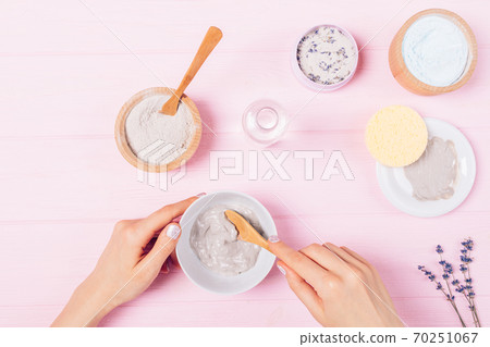 Female hands mix ingredients for clay cosmetic facial mask 70251067