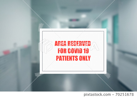 Sign on the door of a hospital corridor indicating an access area reserved for patients with covid-19 70251678