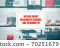 message on a luxury boutique announcing the closure due to the coronavirus 70251679