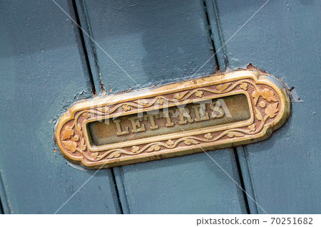 Vintage mailbox inlaid in a blue wooden door Vintage mailbox inlaid in a blue wooden door 70251682