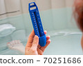 Woman in a hot tub bath controlling the water temperature 70251686